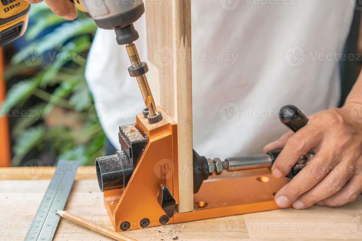 Carpenter use drill bit Pocket hole joinery, or pocket screw joinery, involves drilling a hole at an angle ,make strong joints on wooden plate. D.I.Y and woodworking concept.selective focus. photo
