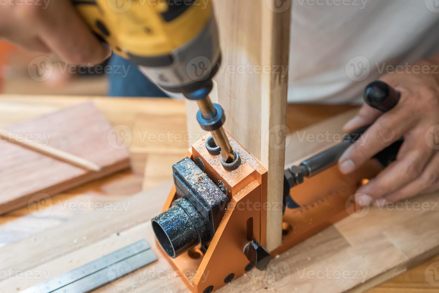 Carpenter use drill bit Pocket hole joinery, or pocket screw joinery, involves drilling a hole at an angle ,make strong joints on wooden plate. D.I.Y and woodworking concept.selective focus. photo