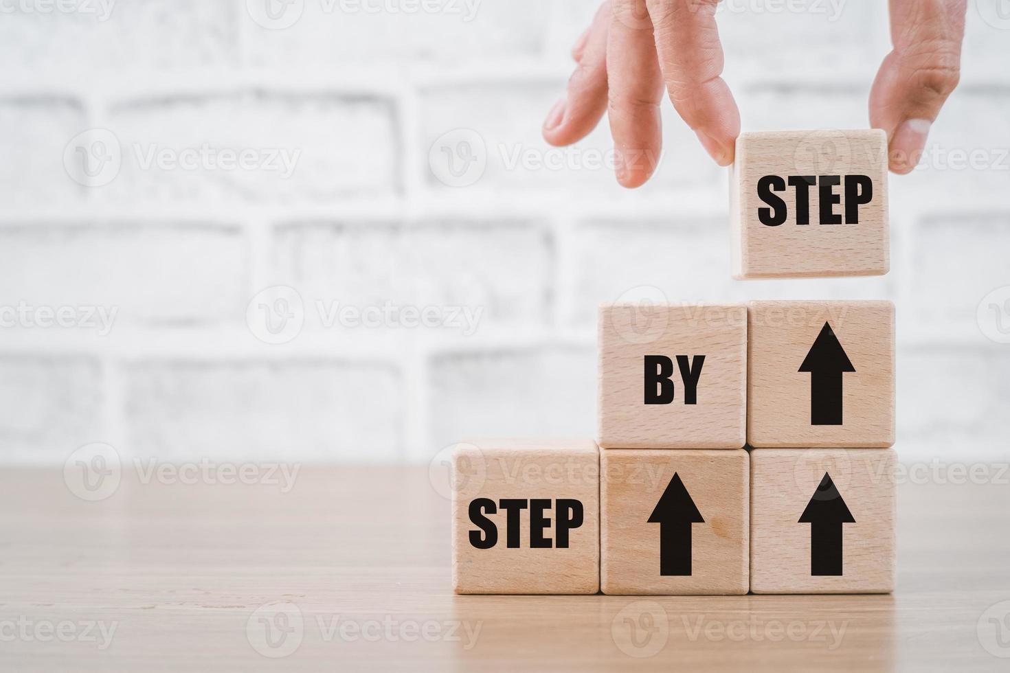 Business concept growth success process, Wooden cubes with message STEP BY STEP. photo