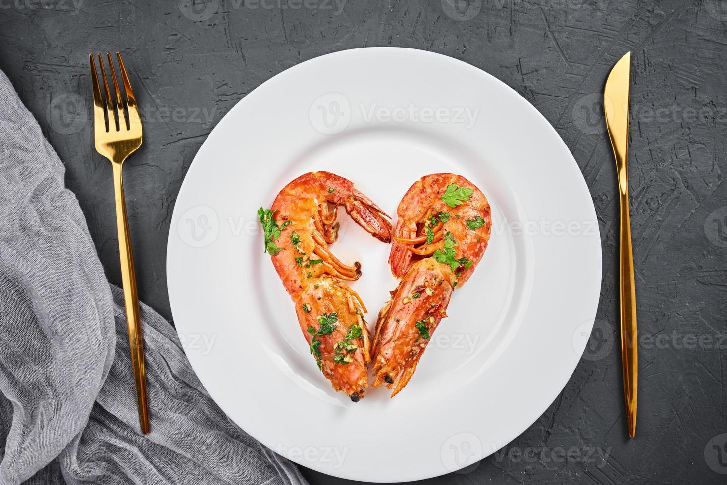 Two shrimps in shape of heart on the plate, top view. Love concept photo