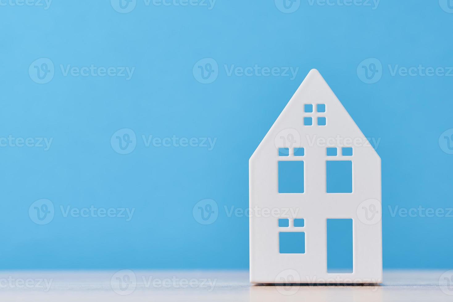 Figure of toy house on a blue background with copy space photo