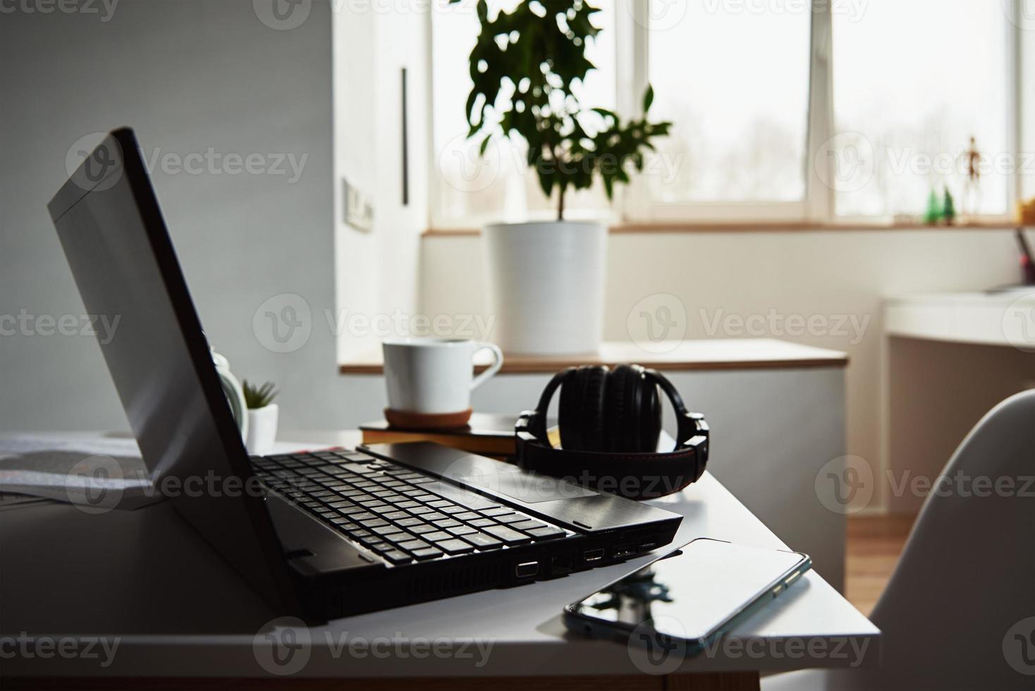 Laptop on table in office interior. Online job and remote work. photo