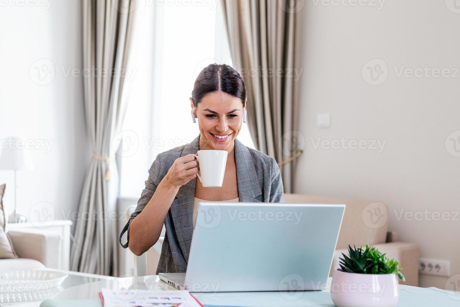 negocio mujer a hogar durante pandemia aislamiento trabajando en ordenador portátil y Bebiendo café.imagen de joven satisfecho contento alegre linda hermosa negocio mujer sentar adentro en oficina utilizando ordenador portátil computadora foto