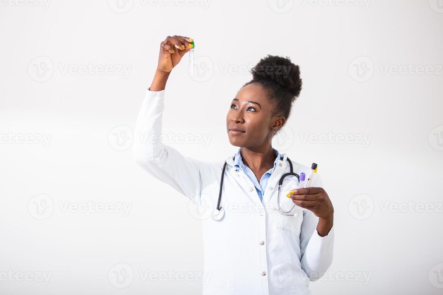 Female doctor in white coat holding blood test tubes in hands while wrapped up in work at modern lab. Female life science professional holding glass cuvette. Healthcare and biotechnology concept. photo