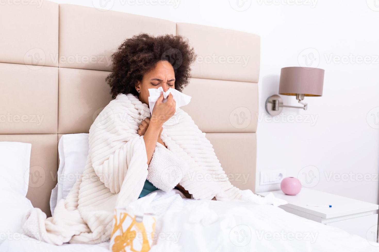 Ill african young woman covered with blanket blowing running nose got