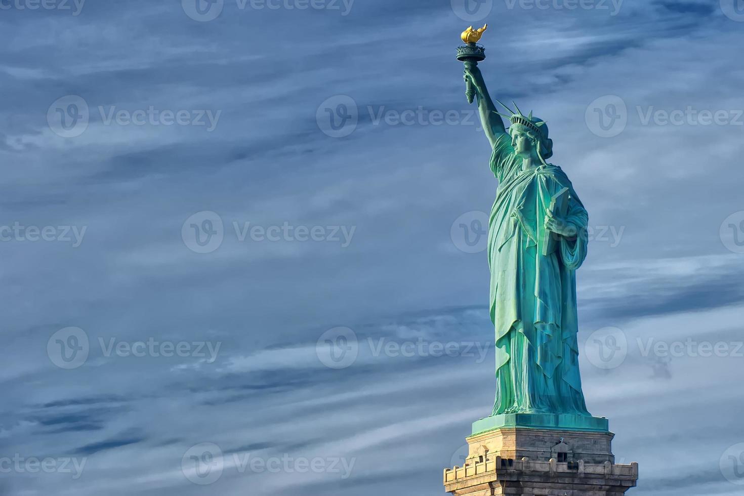 Statue of liberty close up vertical isolated in blue cloudy background photo