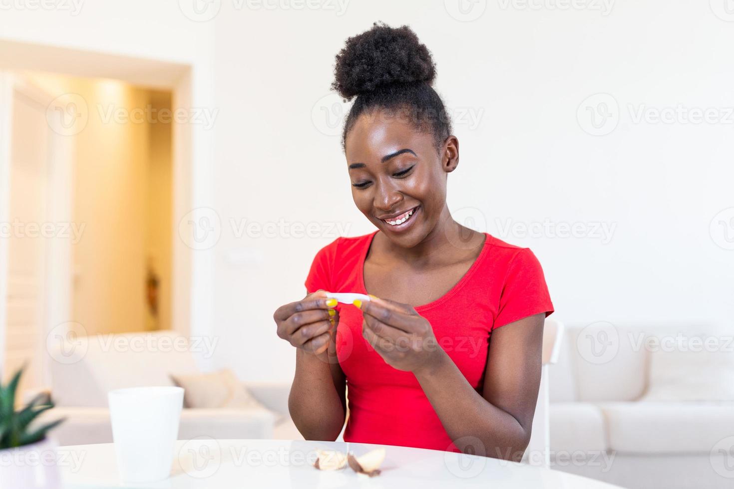 Young african american woman is reading a message from Fortune cookies, does the paper inside of the cookies tell you good things or photo