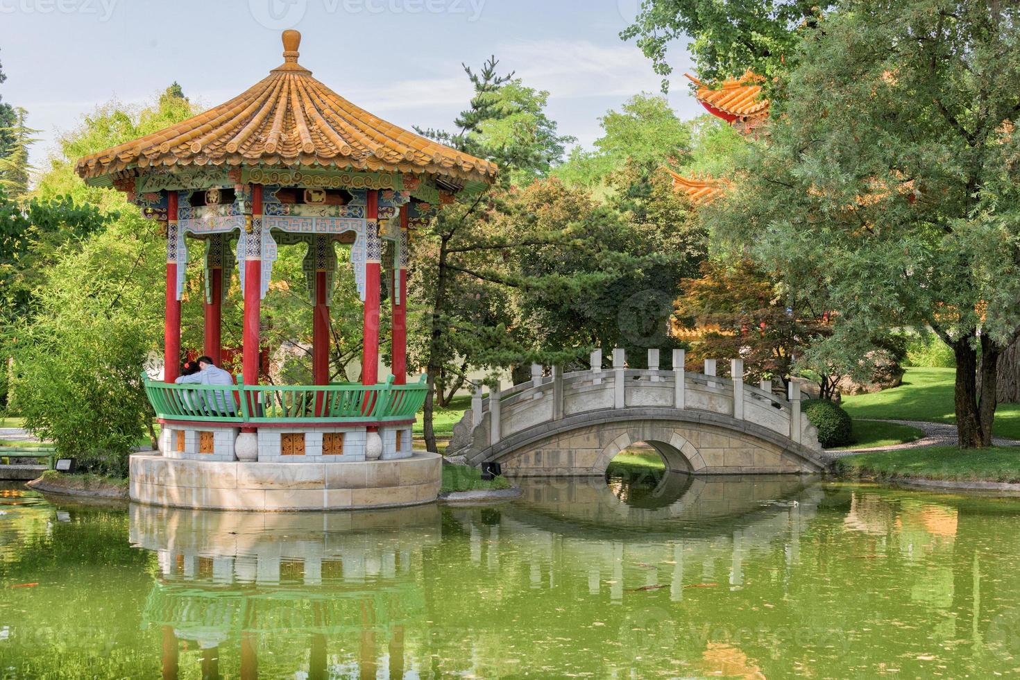 amantes sentado en chino jardín puente foto