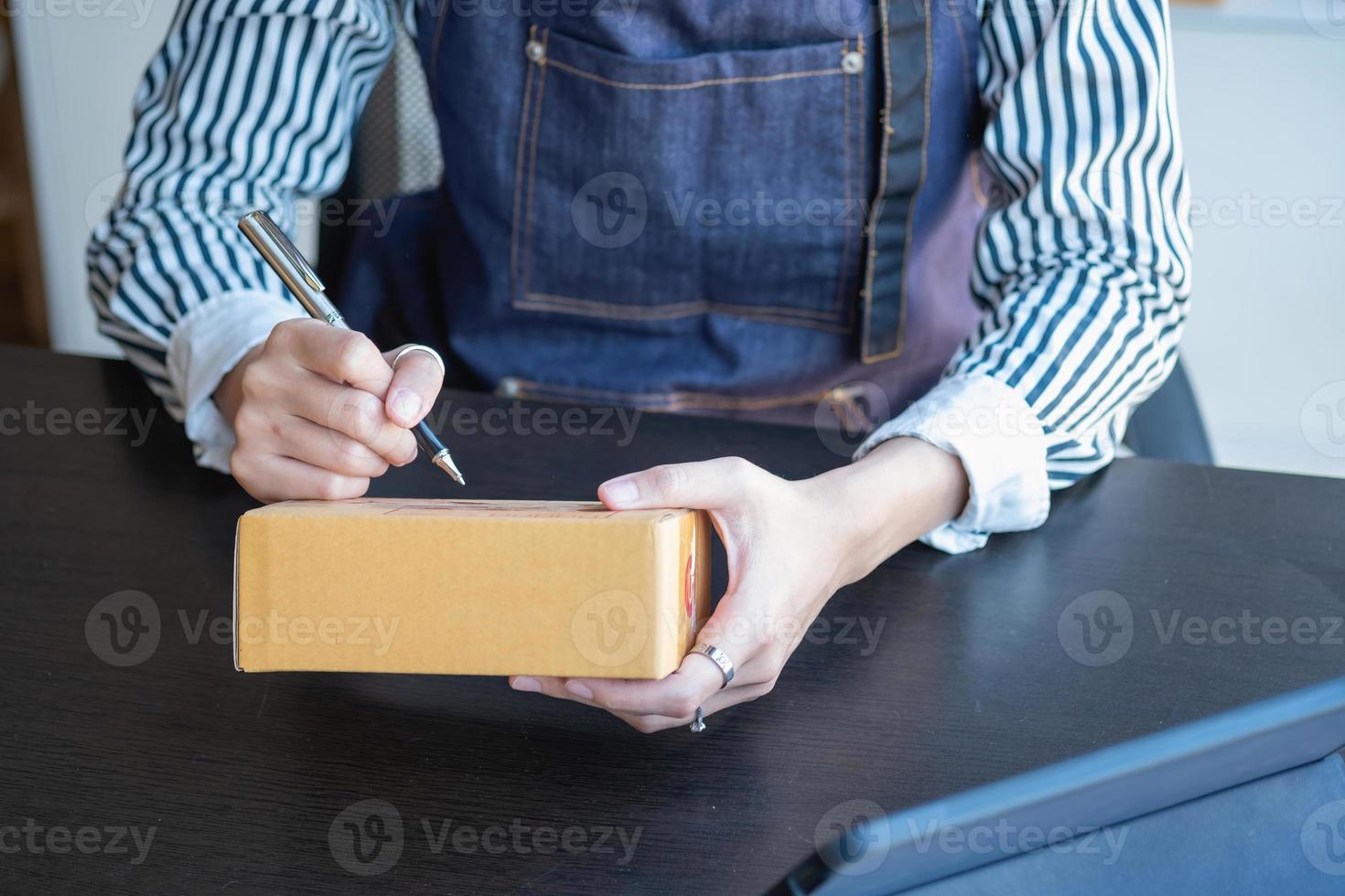 An Asian businesswoman enjoys his online SME business selling products, profiting from opening an online store, and taking orders for customer parcels inside the office. Concept SME Business. photo