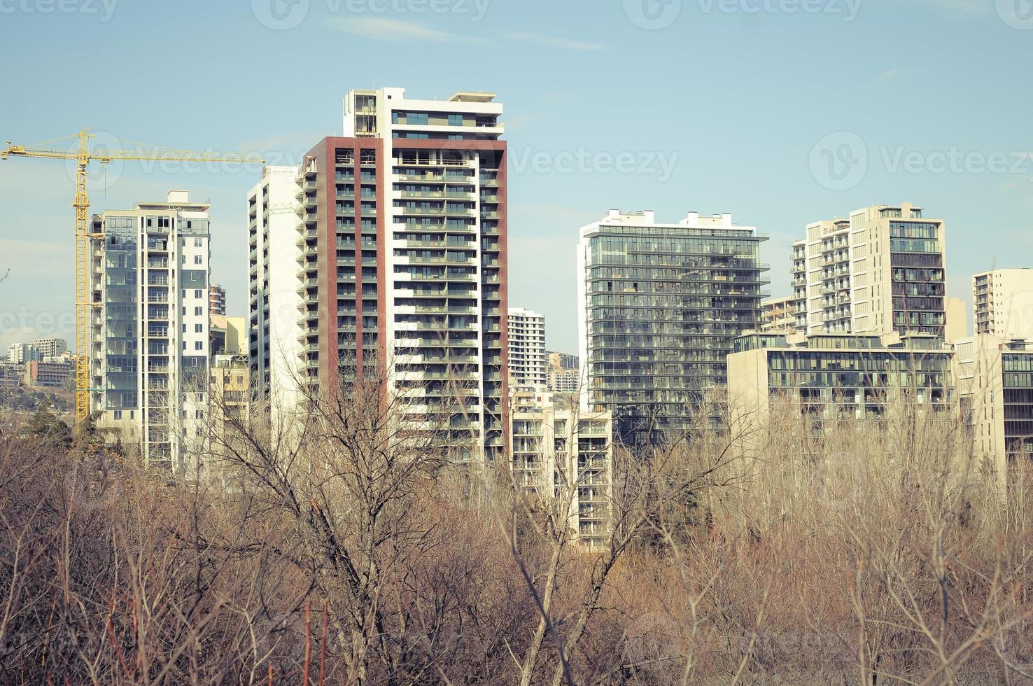 Urban landscape with modern building construction and a lifting crane. photo