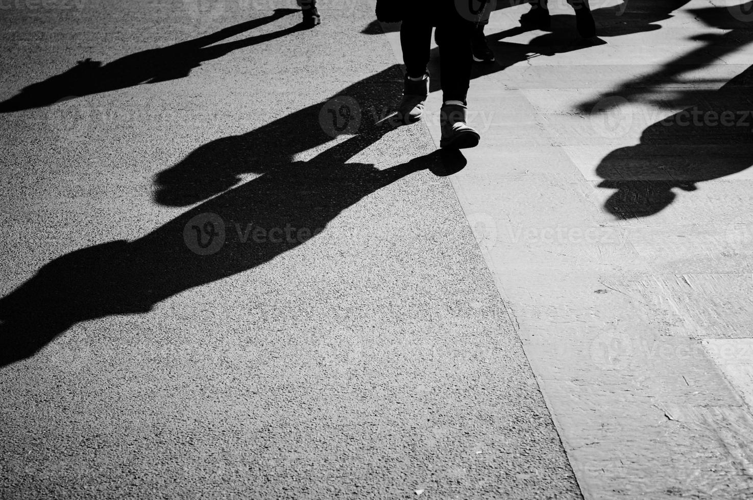 Black and white image of a zebra crossing with humans moving. photo