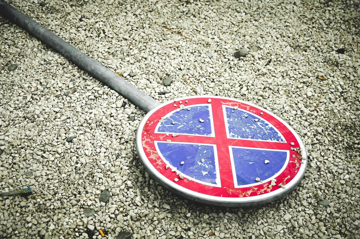 Red and blue prohibition signpost lying on the ground. Fallen road sign. photo