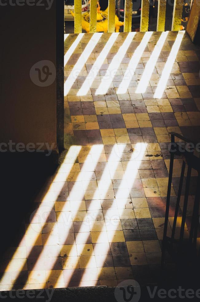 Dark hallway with bright sunlight stripes on the floor. photo