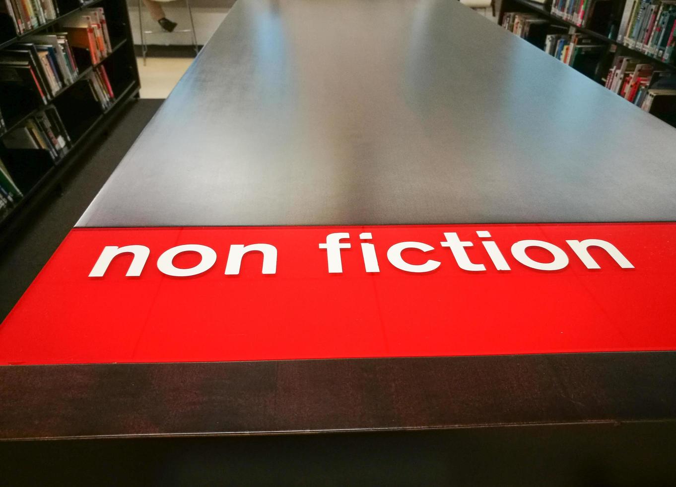 Bookshelves show Non-fiction red sign in a library. photo