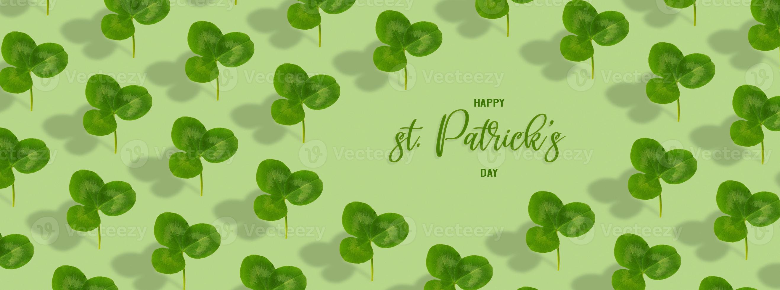 Happy St. Patrick's Day text with clover leaf pattern on colored background. Greeting banner photo