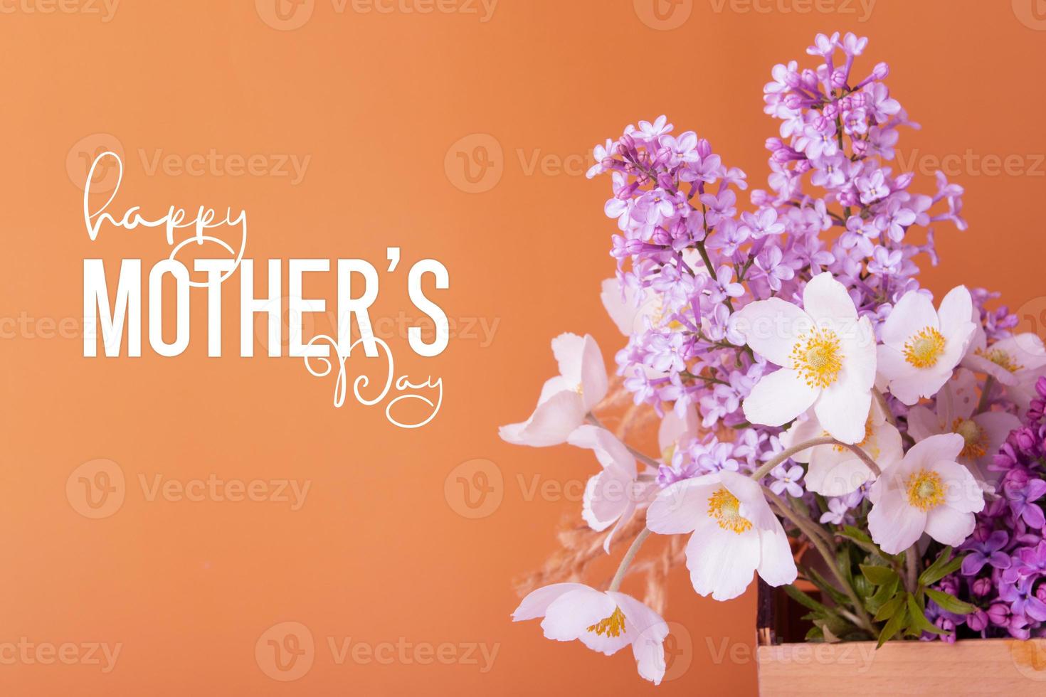 Happy Mother's Day text and lilac and anemones flower bouquet ob colored background photo