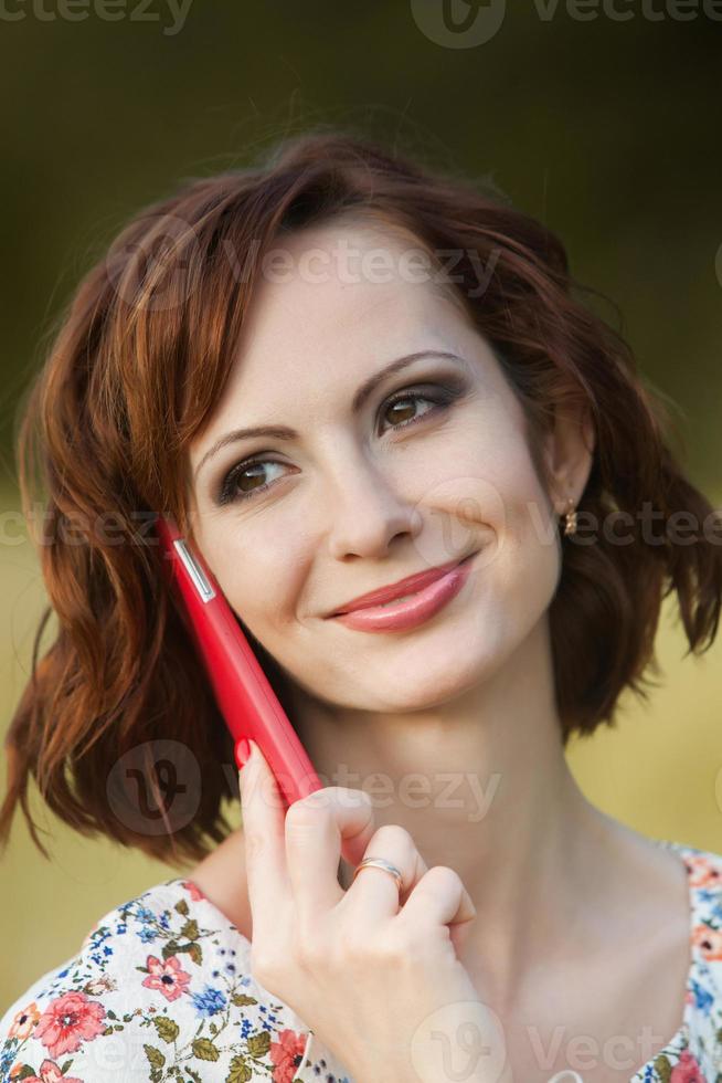 Beautiful woman or business woman talking on a cell phone outside. Outdoor portrait of a beautiful happy businesswoman talking on cell phone. photo