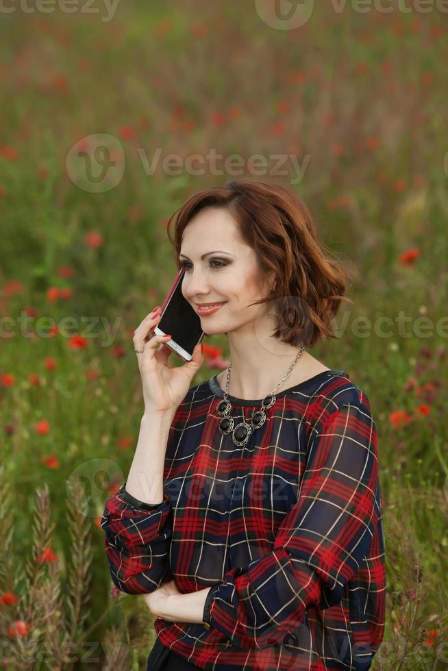 Beautiful woman or business woman talking on a cell phone outside. Outdoor portrait of a beautiful happy businesswoman talking on cell phone. photo