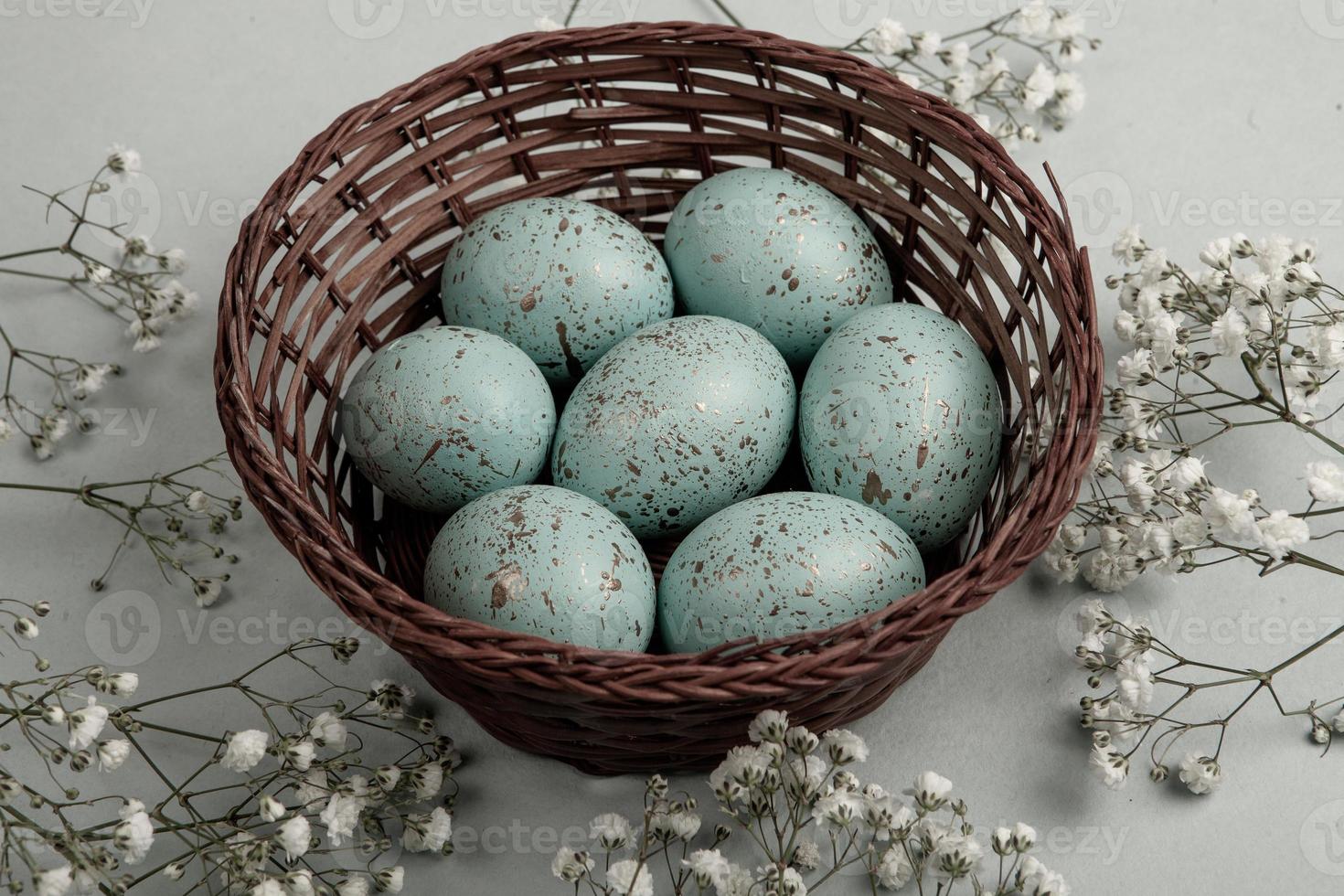 banner. Easter frame with eggs and feathers on a blue wooden background. Minimal concept. View from above. Card with copy space for text. photo