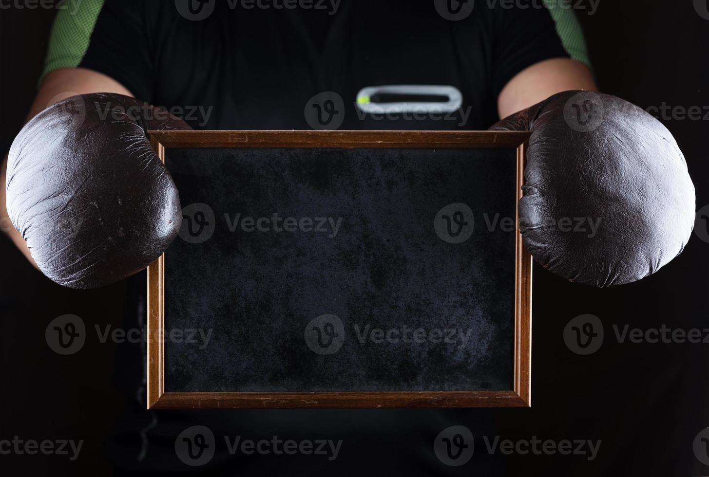 men's hands in boxing gloves hold an empty black frame photo