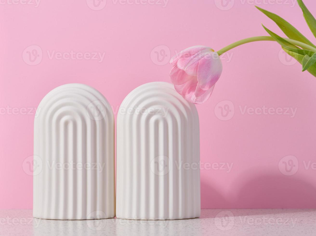 White ceramic decorative arch on a pink background, background for showcasing cosmetics, products, advertising and promotion. photo