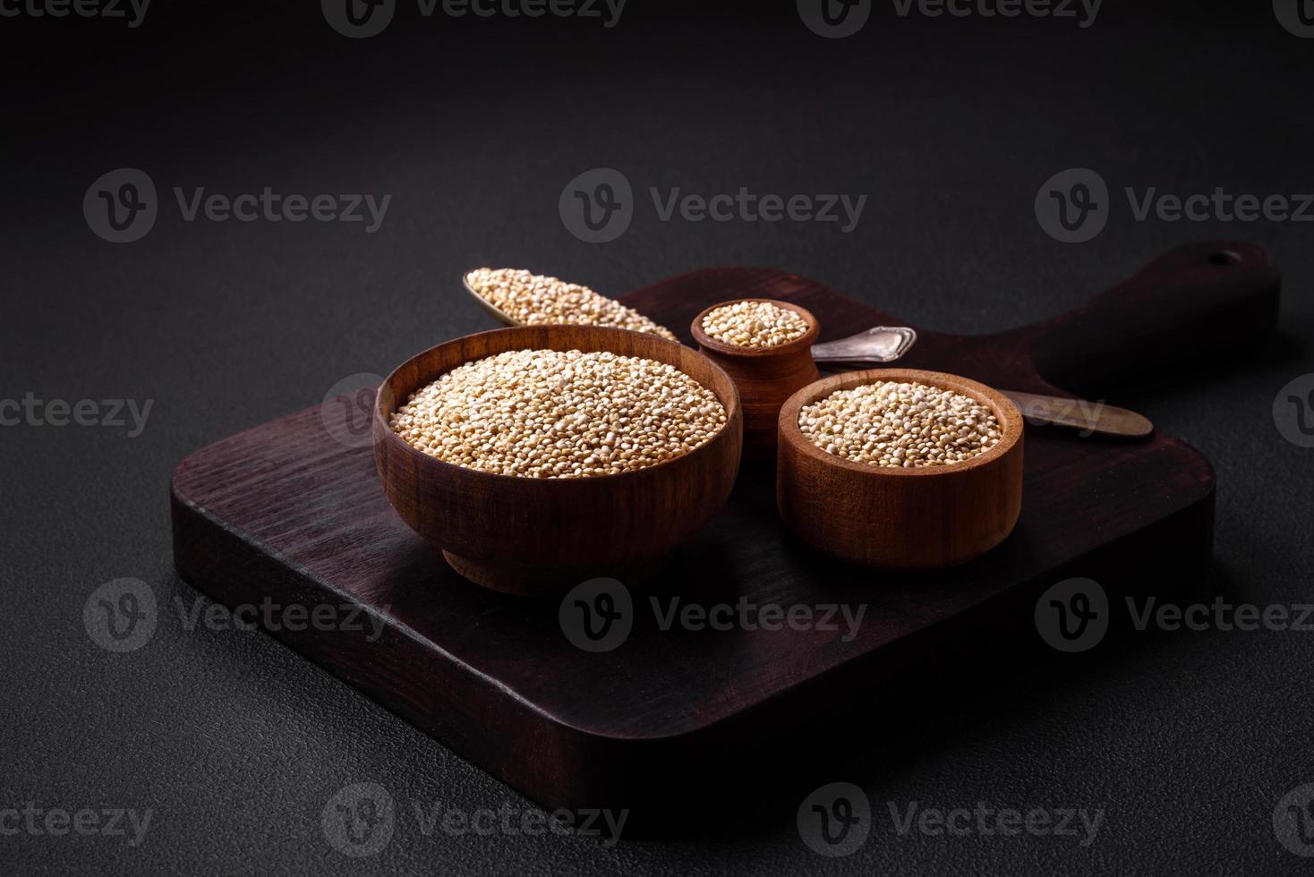 Wholesome raw quinoa in a bowl on a dark concrete background photo