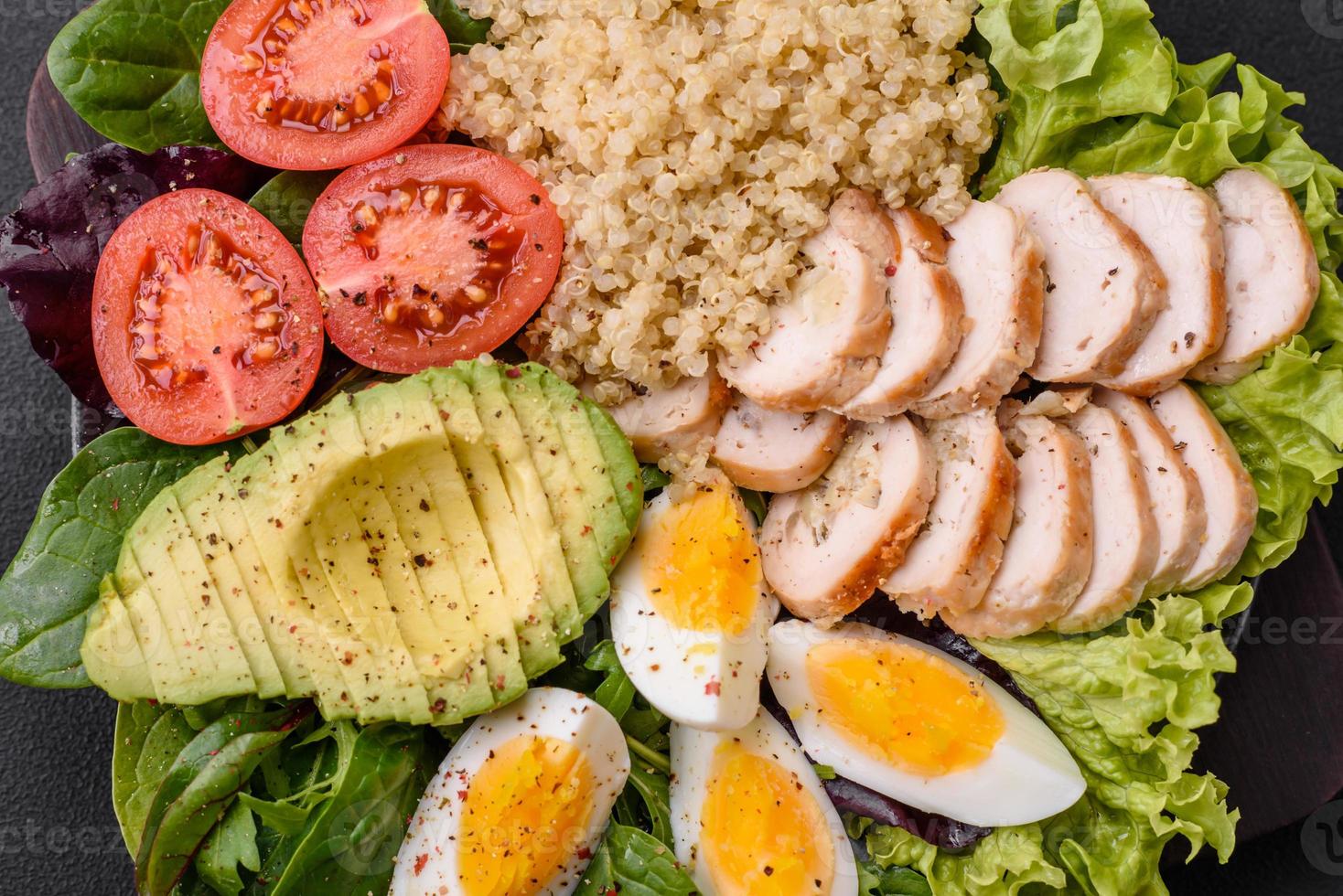 Delicious healthy lunch consisting of chicken, avocado, quinoa, eggs and tomatoes photo