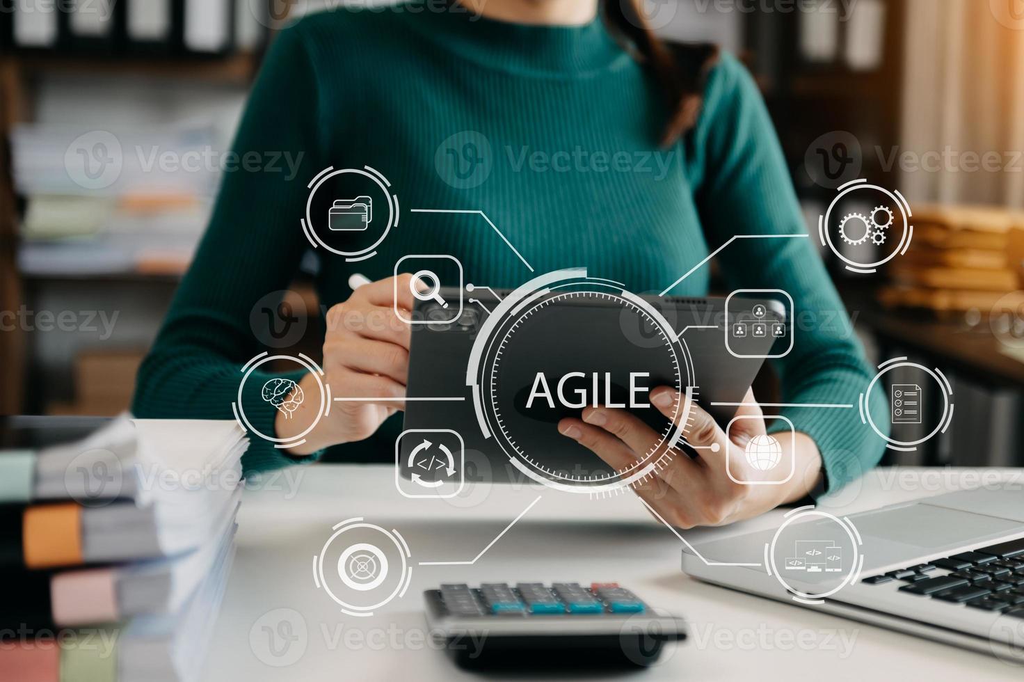 Agile development methodology concept. Business hand using laptop and tablet with virtual screen Agile icon on modern office digital technology concept. photo