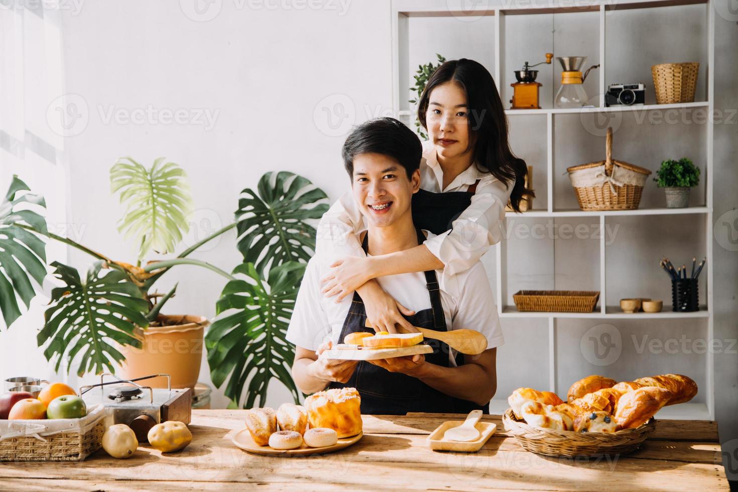 imagen de recién casado Pareja Cocinando a hogar. Asia joven Pareja Cocinando juntos con un pan y Fruta en acogedor cocina en hogar foto