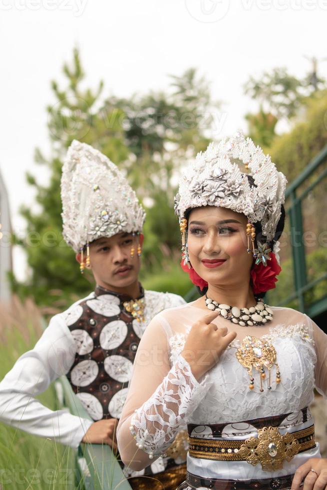 a couple in white clothes posing very intimately and intimately in a park photo