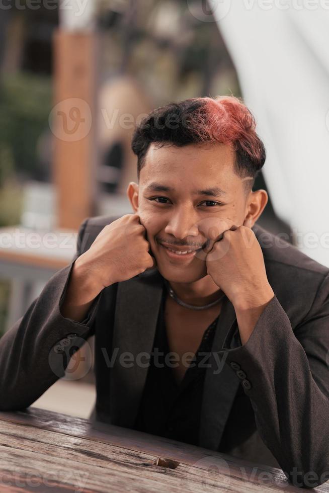 a teenage boy with blond hair poses very funny and cute when wearing a suit photo