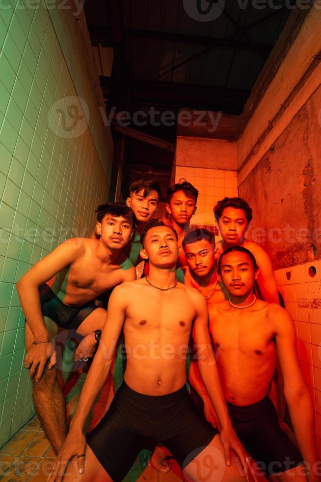 a group of men with open chests and short black pants posing together photo