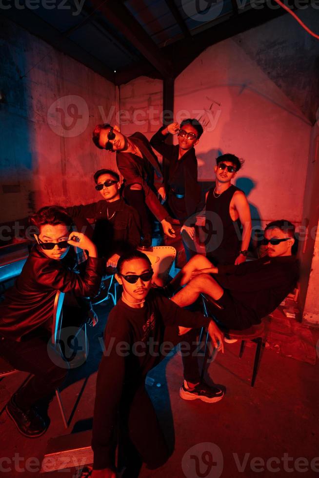 a group of delinquent teenagers wearing glasses and black clothes were sitting and gathering with their friends photo