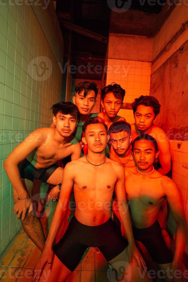 a group of men with open chests and short black pants posing together photo