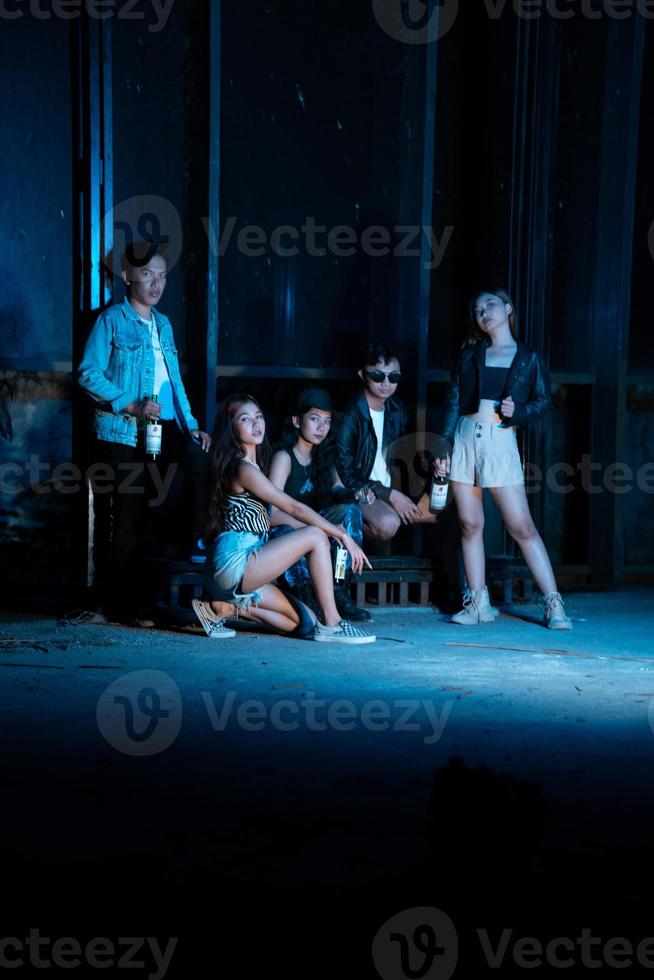 a group of teenagers in quirky clothes posing together as friends in a disco bar with a very cool expression photo