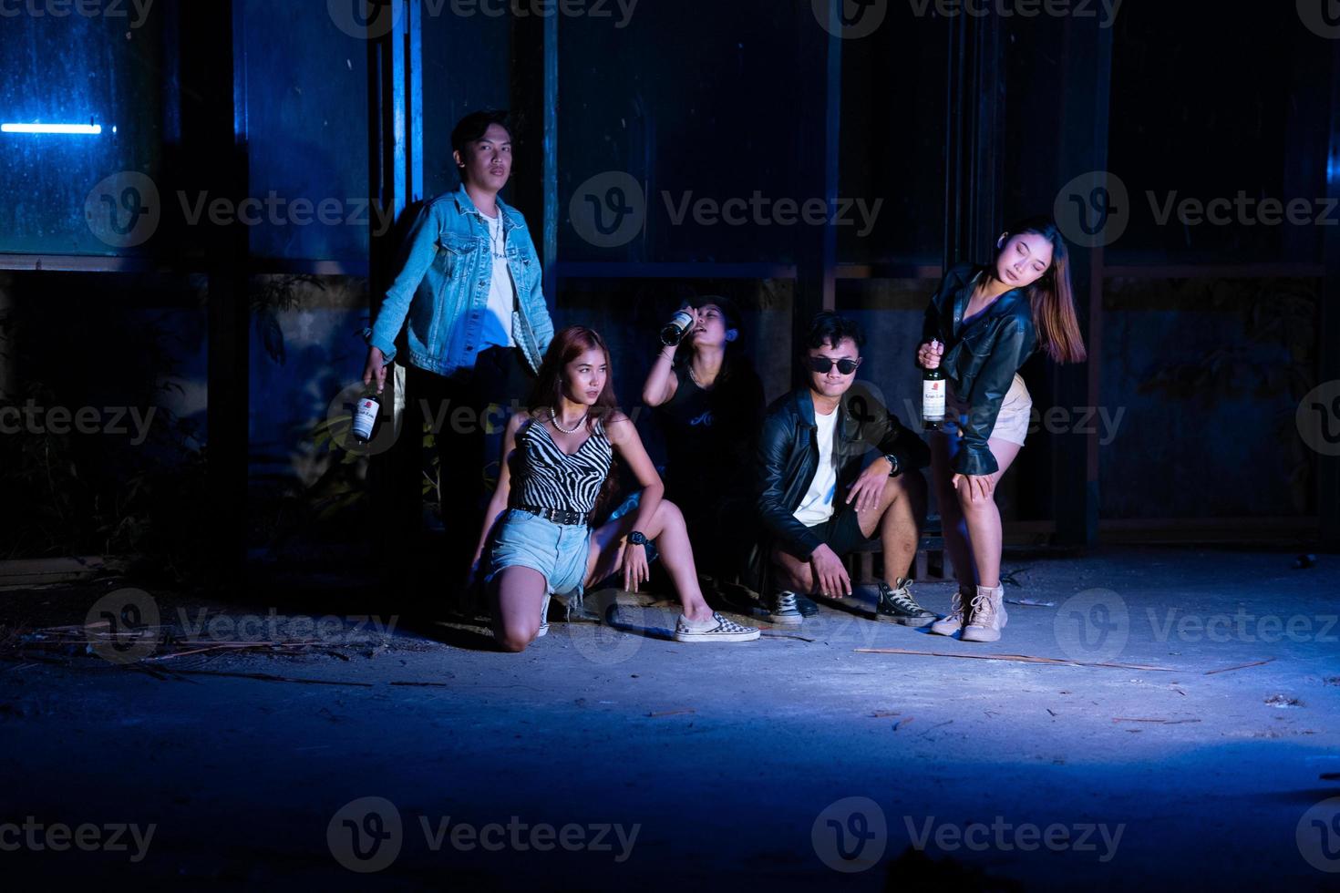 a group of teenagers in quirky clothes posing together as friends in a disco bar with a very cool expression photo