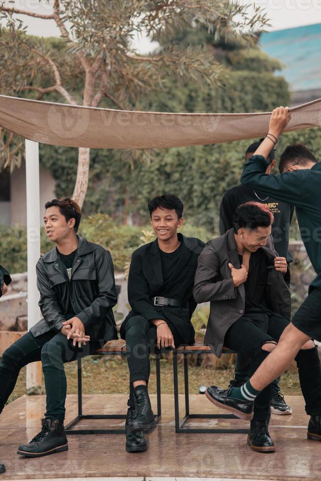 a group of Asian teenagers in black clothes stylized as naughty children while gathering at a cafe photo