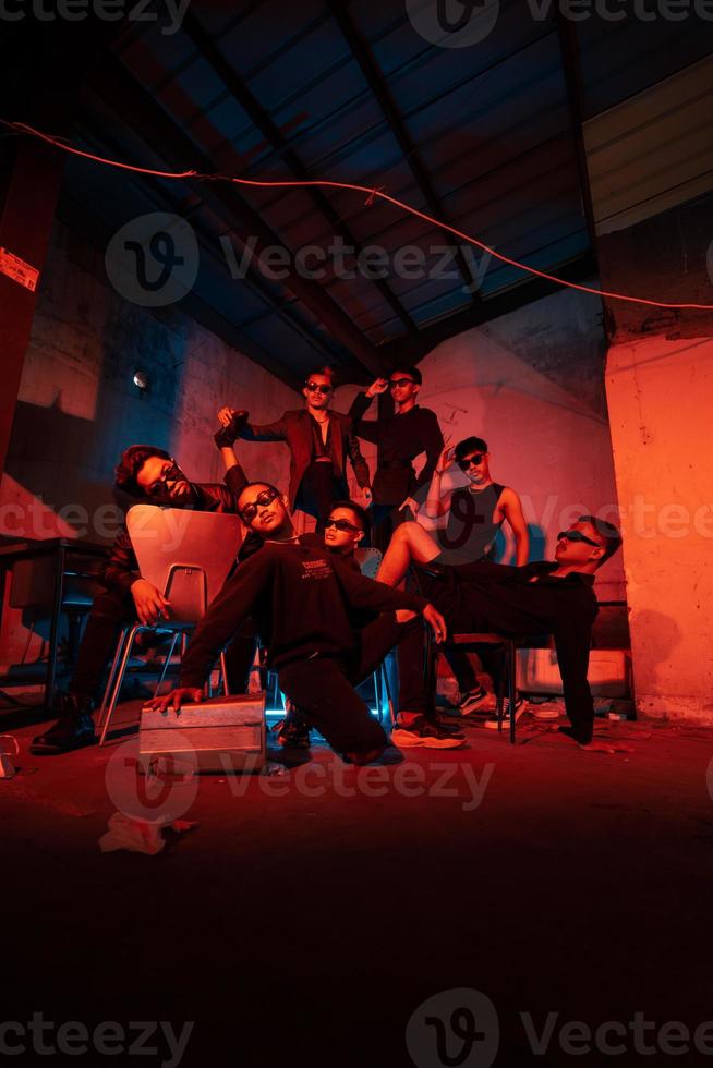 un grupo de matones vistiendo oscuro ropa y lentes fueron teniendo divertido chateando con su amigos en un antiguo edificio foto