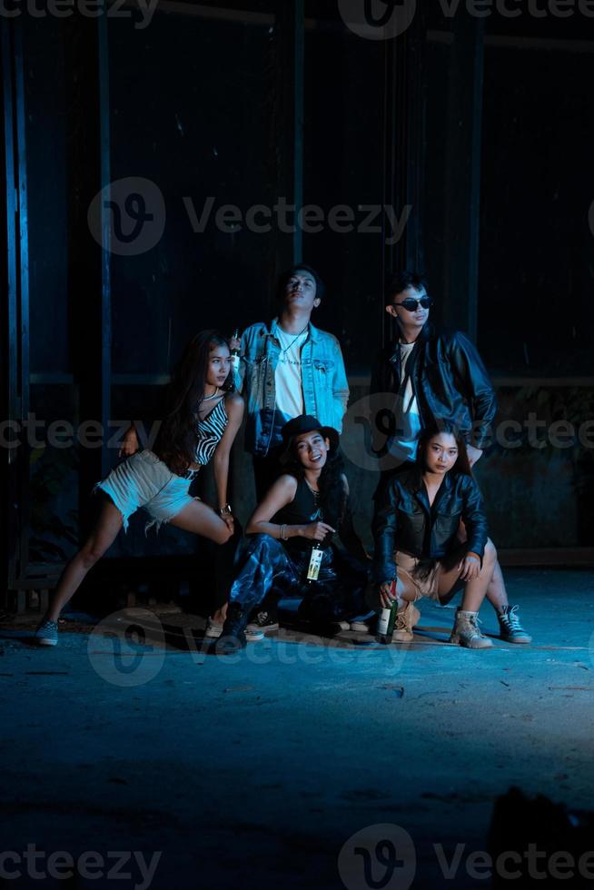 a group of women and men in modern clothes taking pictures together in a clubbing place while celebrating the new year photo