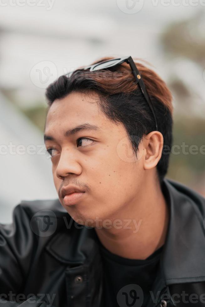 the face of a very silly Asian man with sunglasses on his head while relaxing in a cafe photo