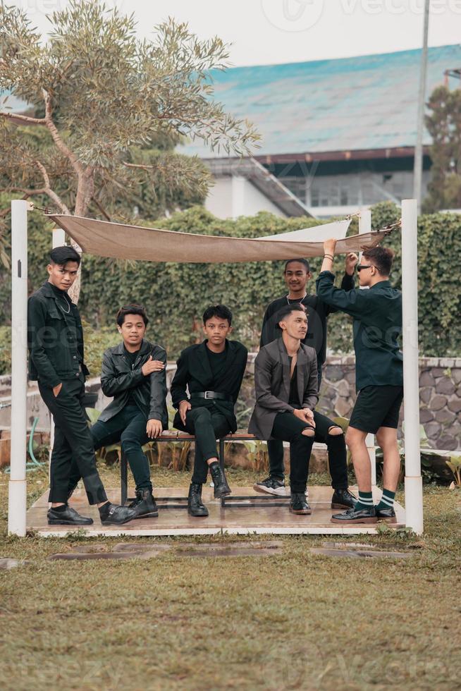 a group of Asian teenagers in black clothes stylized as naughty children while gathering at a cafe photo