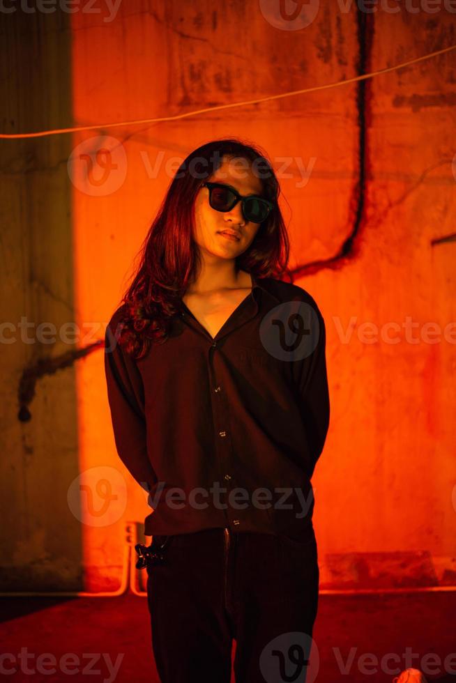 a man with long hair wearing a black shirt and clothes posing very sexy in an old factory photo