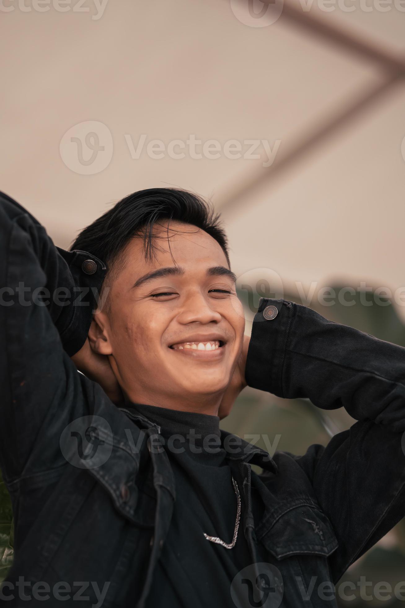 An Asian Man In A Black Denim Jacket And A Chain Necklace Posing