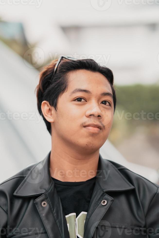 el cara de un muy tonto asiático hombre con Gafas de sol en su cabeza mientras relajante en un café foto