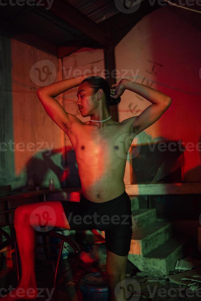 a gay man in short black pants posing hotly on a chair photo