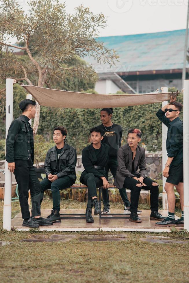 a group of Asian teenagers in black clothes stylized as naughty children while gathering at a cafe photo