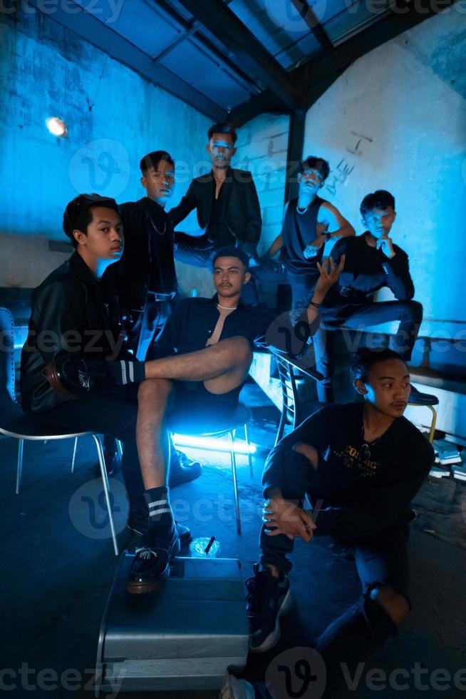 a group of Asian teenagers in black clothes gathered at a headquarters when meeting with their friends photo