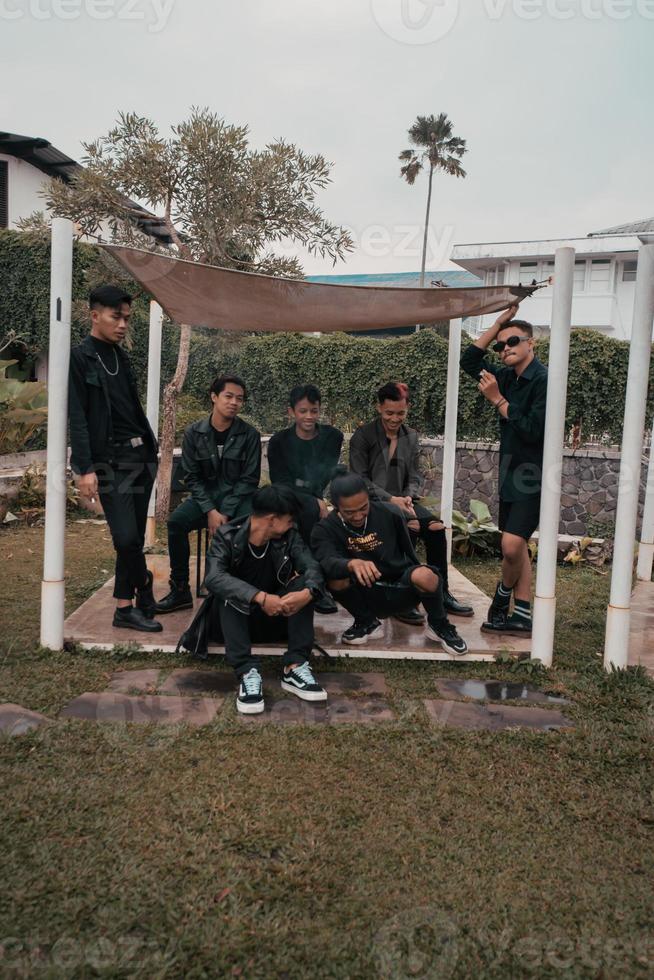 a group of Asian teenagers in black clothes stylized as naughty children while gathering at a cafe photo