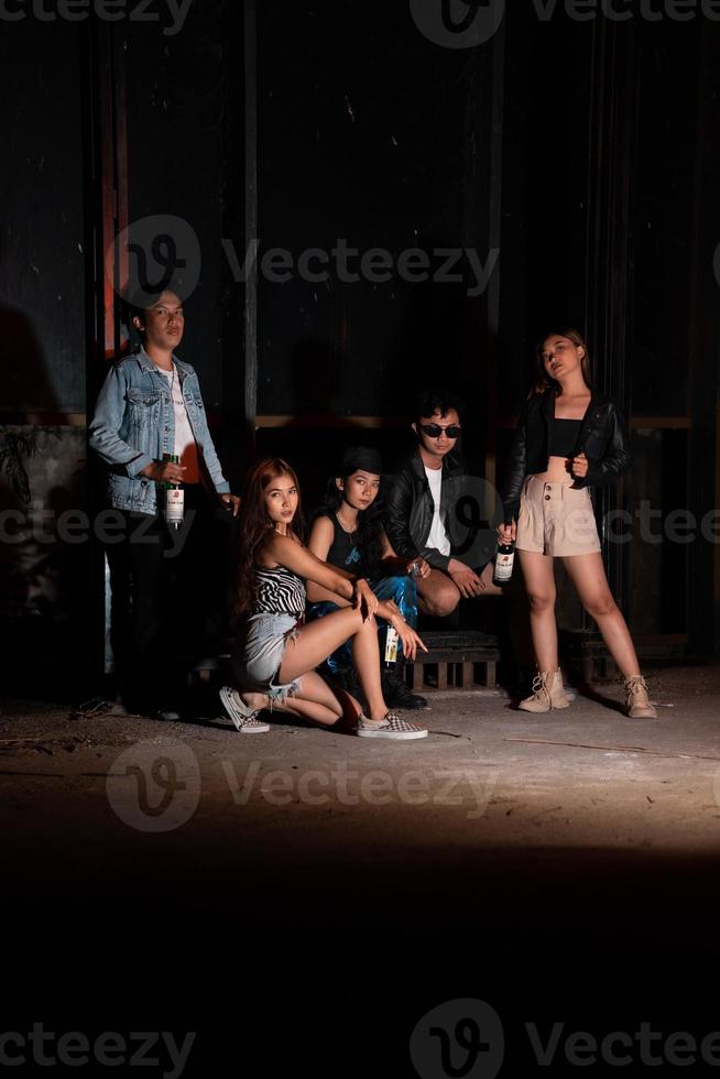 un grupo de adolescentes en peculiar ropa posando juntos como amigos en un disco bar con un muy frio expresión foto