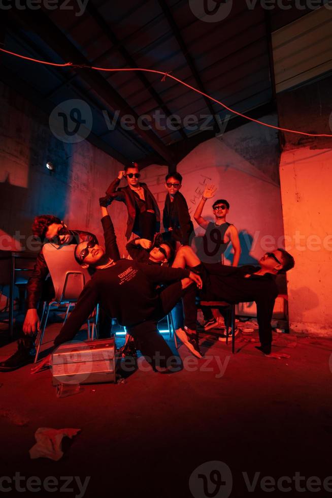 a group of thugs wearing dark clothes and glasses were having fun chatting with their friends in an old building photo